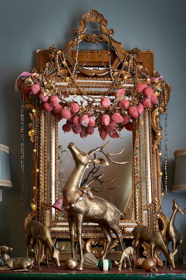 Vintage brass deer with ornate mirror backdrop and vintage pear garland.