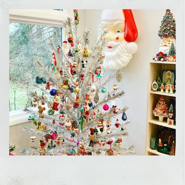 Silver aluminum tree with vintage ornaments. Blow mold Santa on wall.