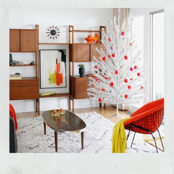 Midcentury modern living room with silver aluminum tree and red and pink ornaments.