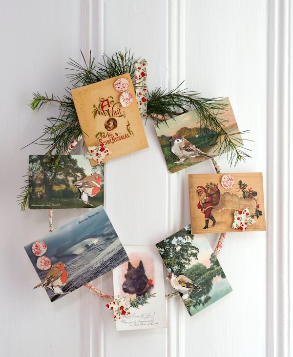 Wire bent into a circle covered in strips of vintage fabric and embellished with greenery and holiday cards clipped on.