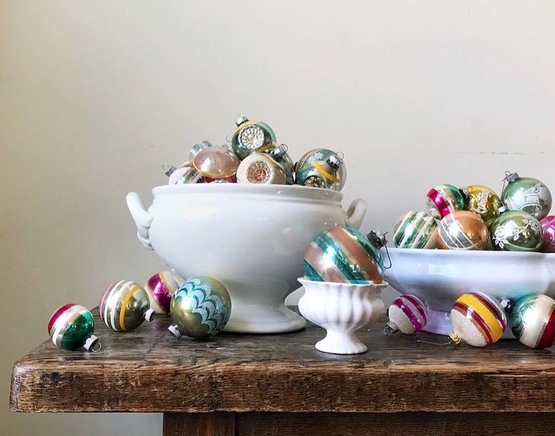Vintage ornaments displayed in vintage ironstone serving bowls.