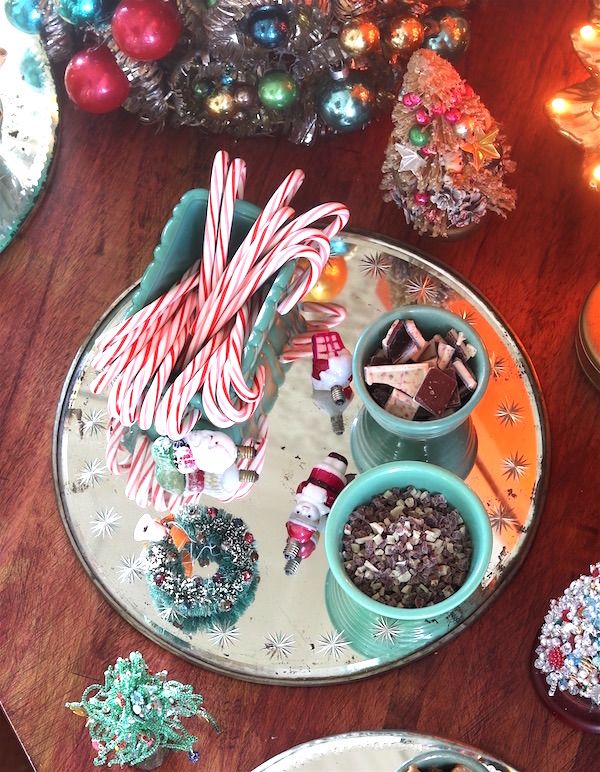 Candy canes in McCoy pottery and candies in vintage bowls on old mirror as tray.