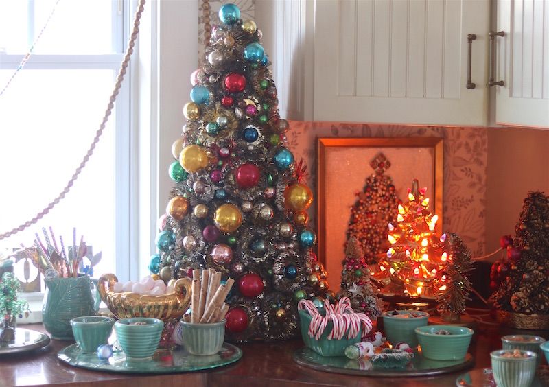 Hot chocolate buffet with vintage decorated Christmas tree and green vintage dishes.