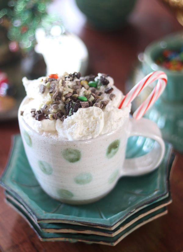 Green and while polka dot mug with hot chocolate and whipped cream.