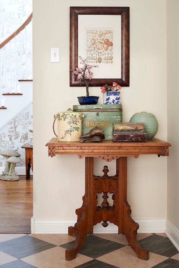 Vintage art hung over vintage table with antique accessories.
