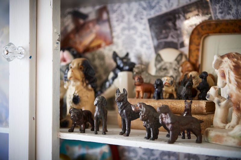 Cast iron dogs displayed in vintage cabinet.