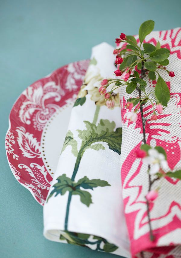Pink floral napkins with pink and white patterned plate and crab apple blossoms.