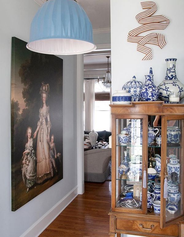 Blue and white ceramics and pottery displayed in vintage glass cabinet.