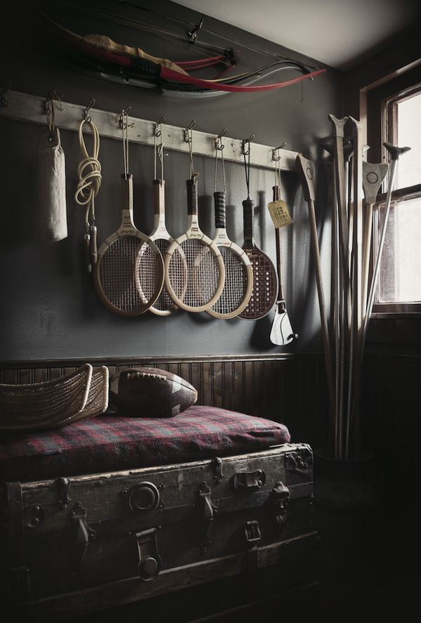 Vintage tennis rackets hanging over an old trunk.