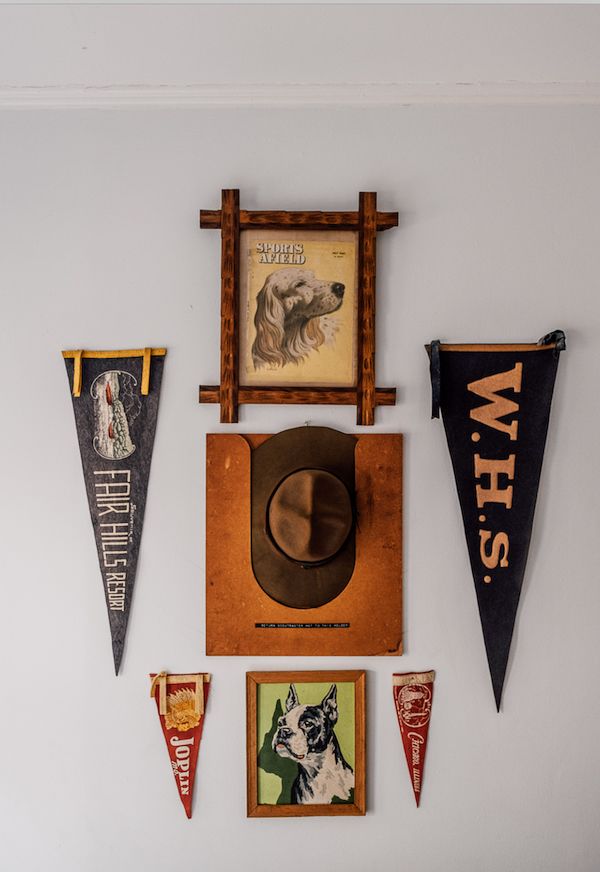 Vintage pennants and framed dog paintings on wall.