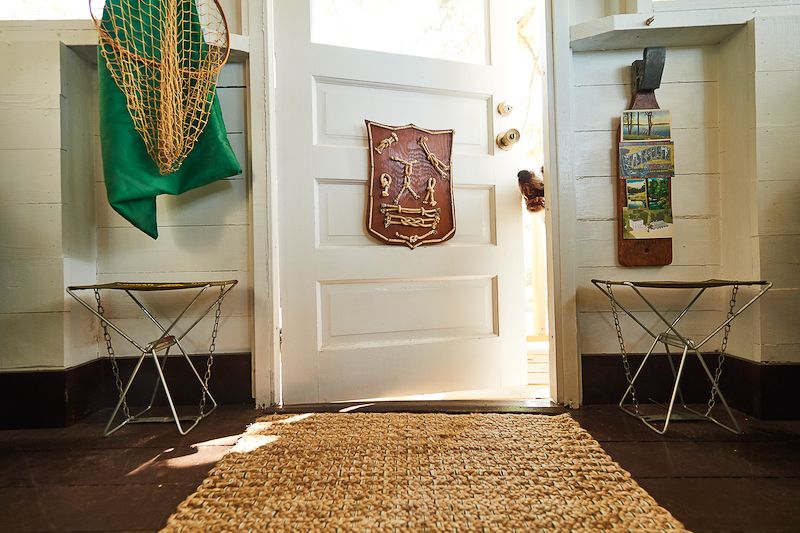 A fish-cleaning board repurposed as an artsy postcard holder in entry of cabin.