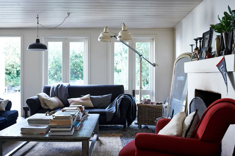 Natural light flooding into open-plan living room with five sets of recycled French doors.