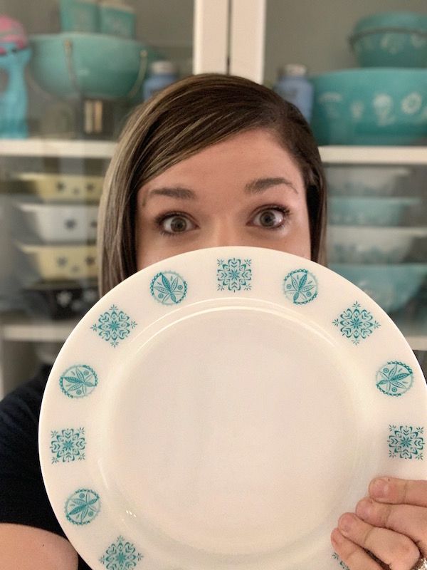 Collector, Megan Telfer, behind a Pyrex plate.
