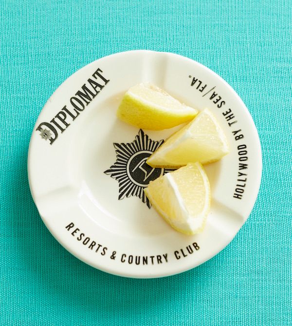 Vintage ashtray being used as a dish for cut lemon slices.