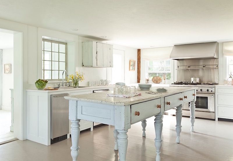 Kitchen with white walls and rustic white cabinets and center island.
