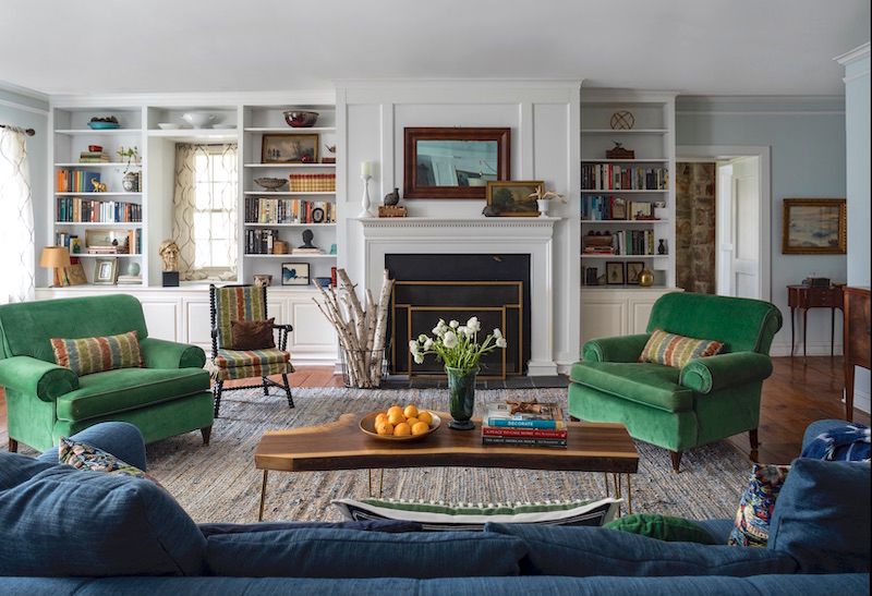 Living room with vintage furniture and accessories, including green chairs.