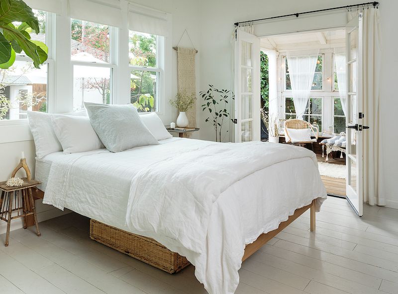 White walls and bedding in bright and breezy bedroom.
