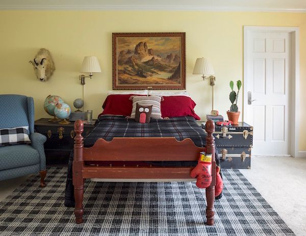 Boy's room decorated with vintage furniture and accessories including a taxidermy mountain goat and vintage boxing gloves.