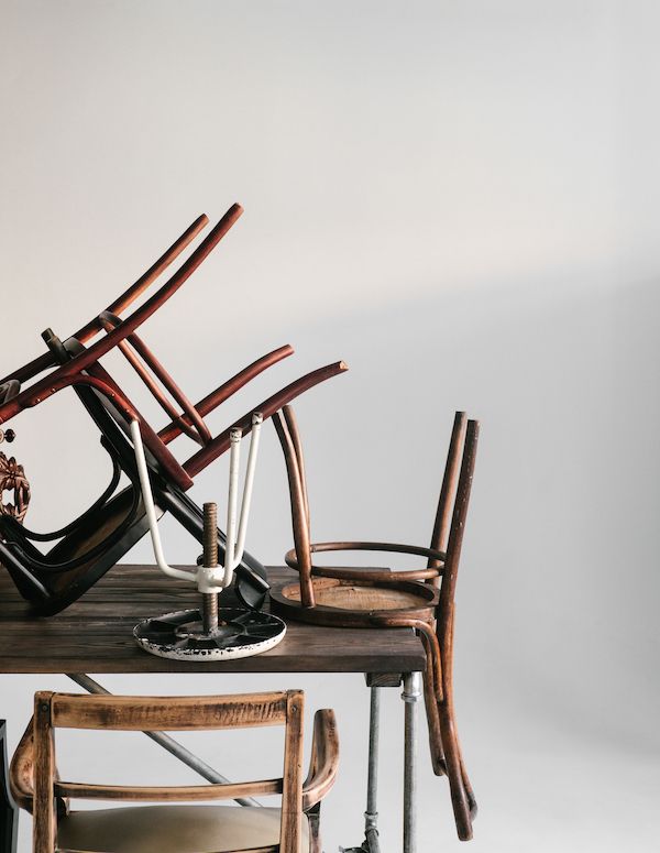 Stack of old chairs and stools on a vintage table.