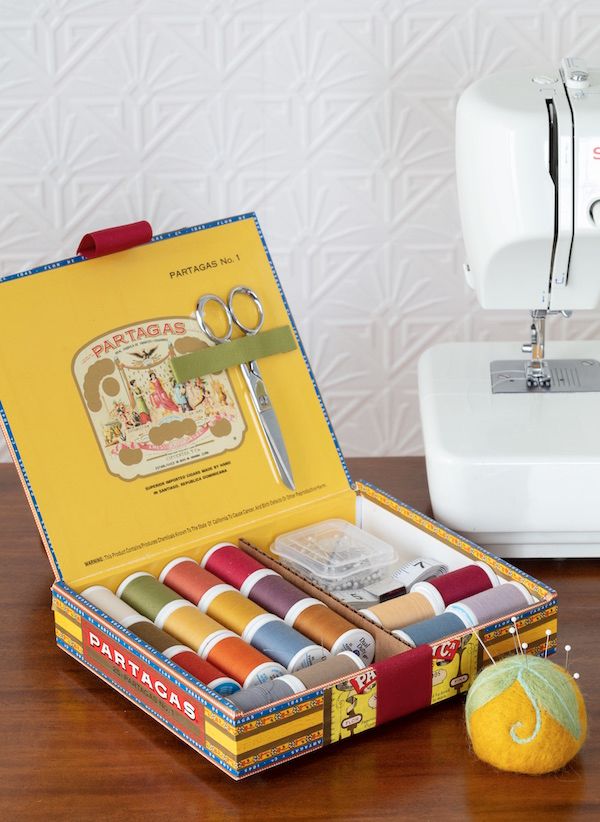 Vintage cigar box used as a container for a sewing kit.